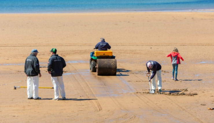 beach cricket,pitch blows,makes together,hit ball in water,near tourist,out,gali cricket,rules,8 players,white kit,weird story