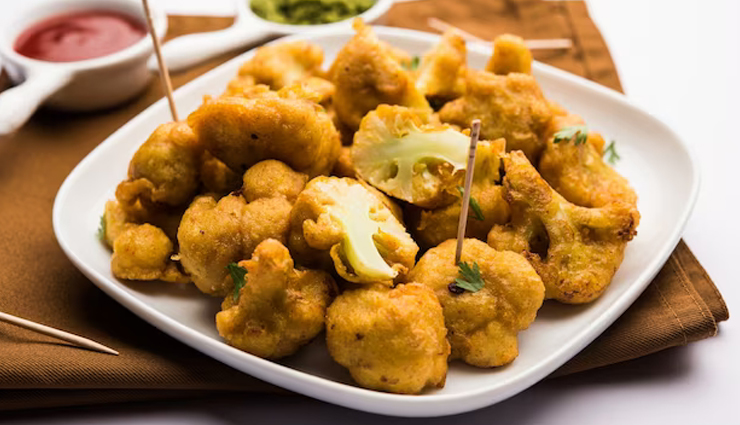 gobi ke pakode recipe,cauliflower fritters,indian snack,gram flour batter,spices,deep-fried,crispy,tangy dipping sauce,tamarind,mint,cilantro,vegetarian snack,high protein,high fiber,nutritious,easy to prepare,party food,appetizer,rainy day snack,besan,rice flour,golden brown,quick and easy